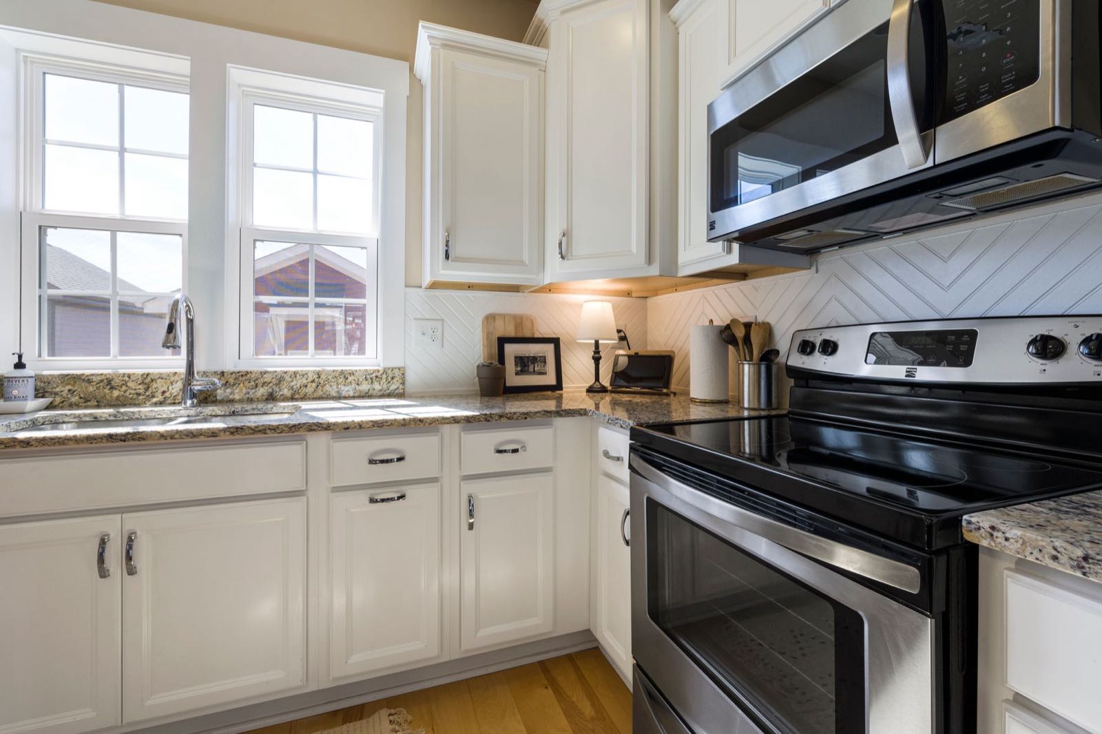 Bright kitchen with white painted cabinets and stainless steel appliances