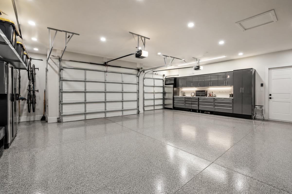 Gray flake epoxy floor coating in a three-car garage at a home in Fiddler's Creek, Naples, FL, installed by Bryan's Painting and Home Finishes