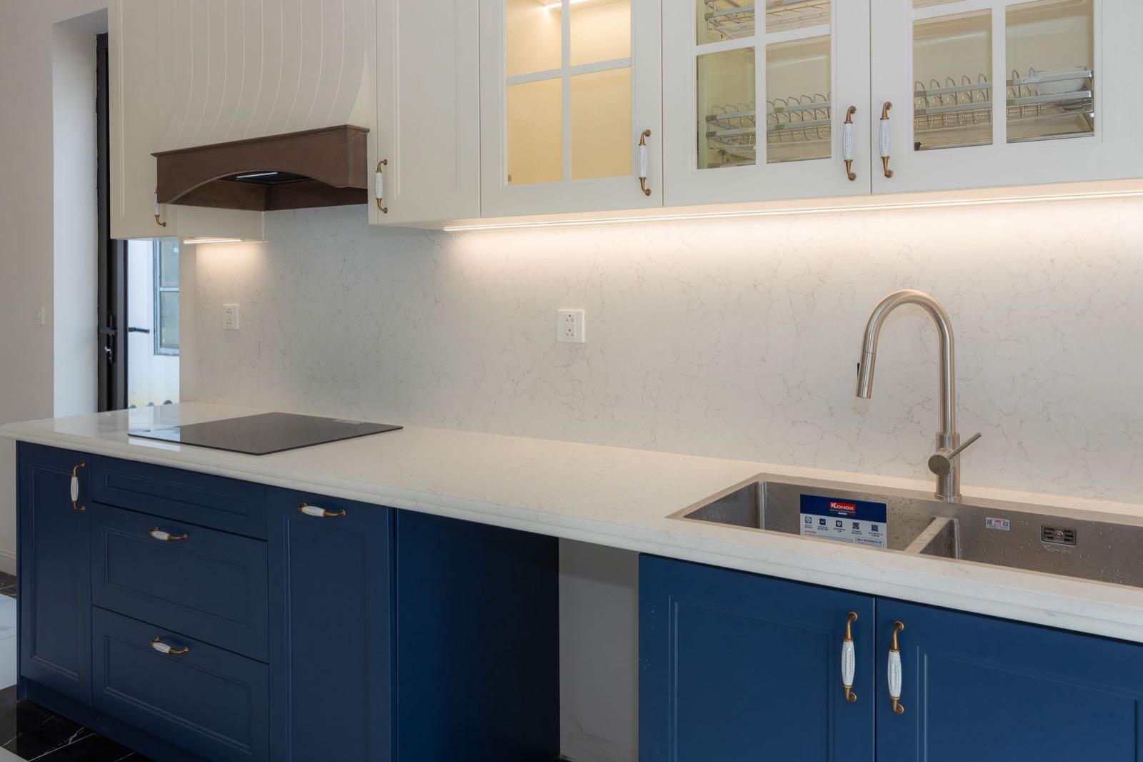 Refinished kitchen cabinets with navy painted lower doors and drawers and white painted upper cabinets